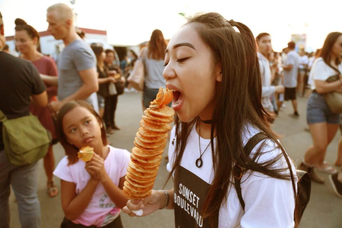 Girl eating a skewer of food