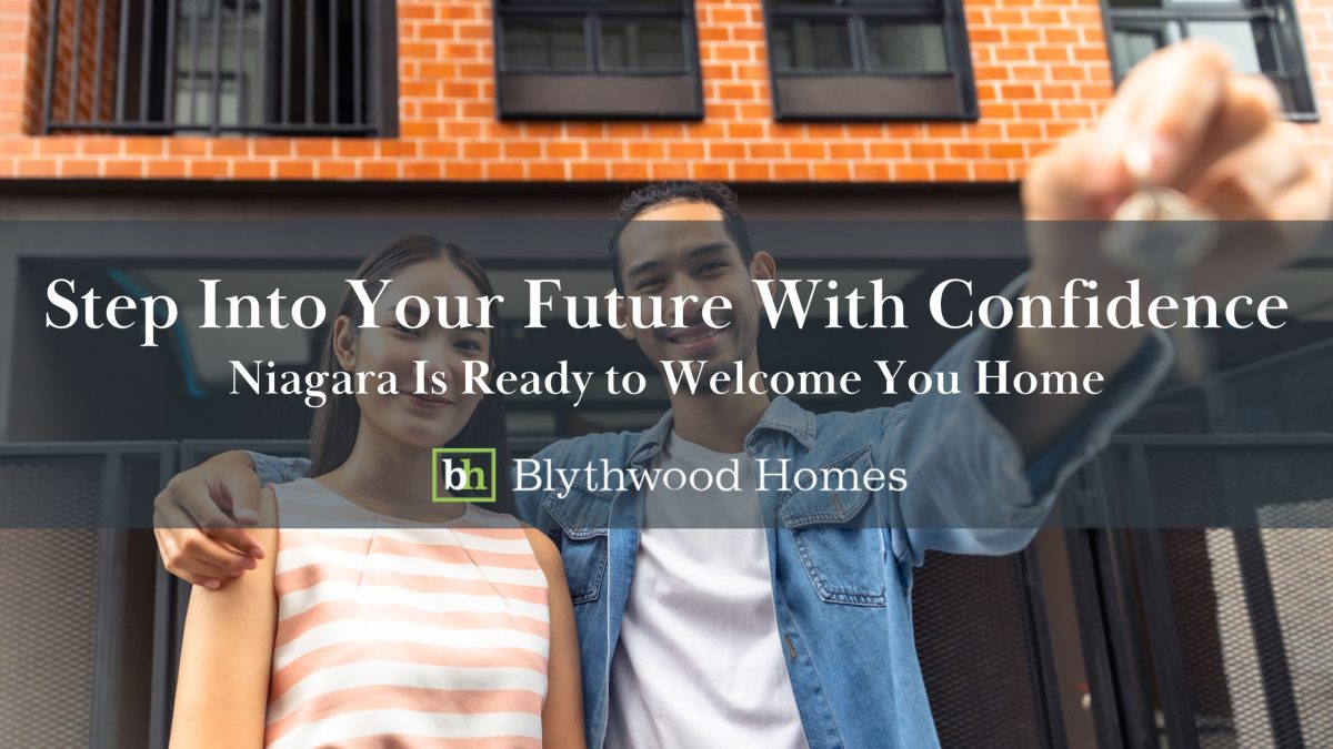 A smiling young couple stands in front of a modern apartment holding house keys, symbolizing their first home purchase in Niagara with Blythwood Homes.